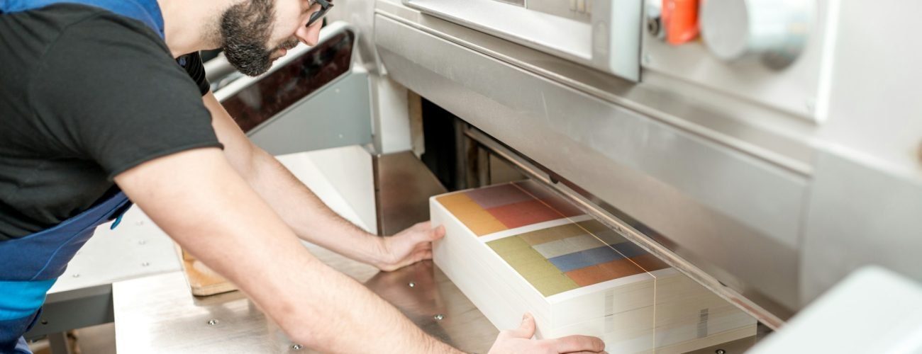 Man working with cutting machine at the printing plant